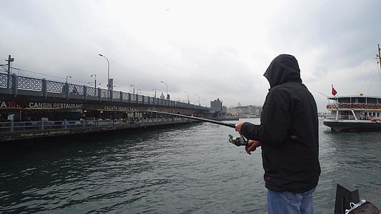 人类在雨天在加拉塔桥上钓鱼视频的预览图