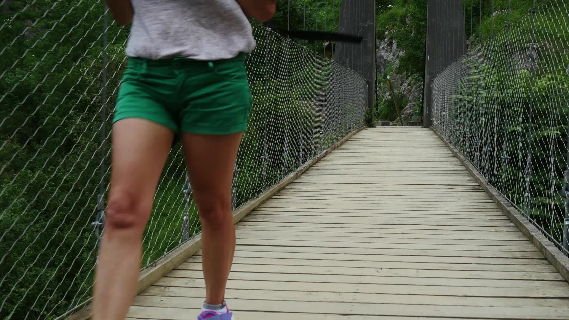 女性徒步旅行者在比利牛斯的霍尔扎特吊桥上行走视频的预览图