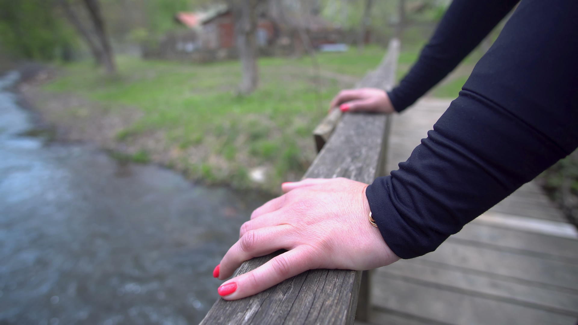 红色指甲的女性在河桥上使用木栅栏视频的预览图