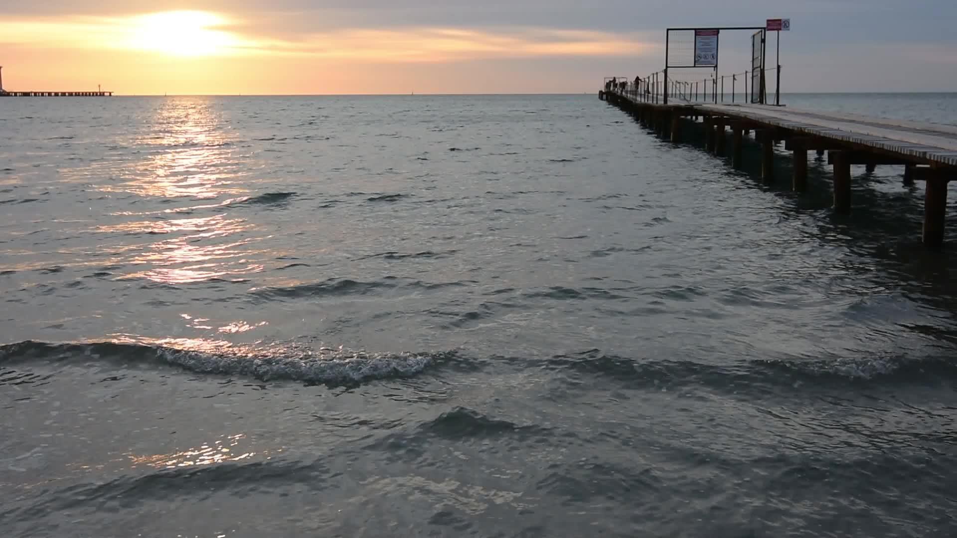 黄昏的海日落在码头的右边视频的预览图