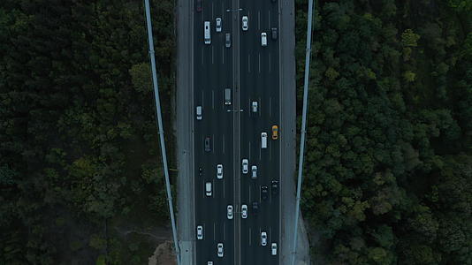 在森林和汽车交通之间开放的桥梁公路高速公路空中鸟眼视频的预览图