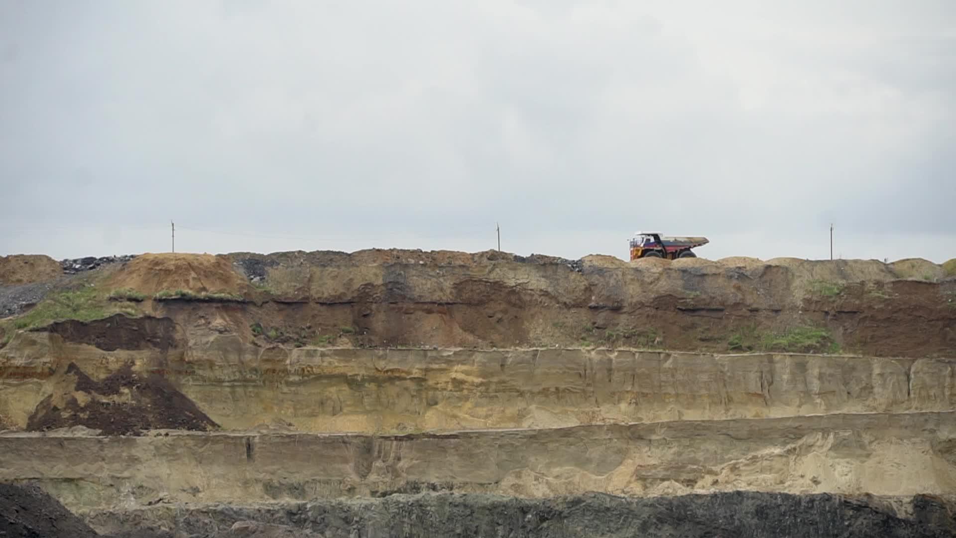 一辆倾卸卡车经过一个采石场其中一具装满土壤的尸体视频的预览图