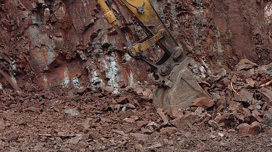 挖掘机清理地面挖掘机铲斗清除岩石装载在卡车上使用视频的预览图