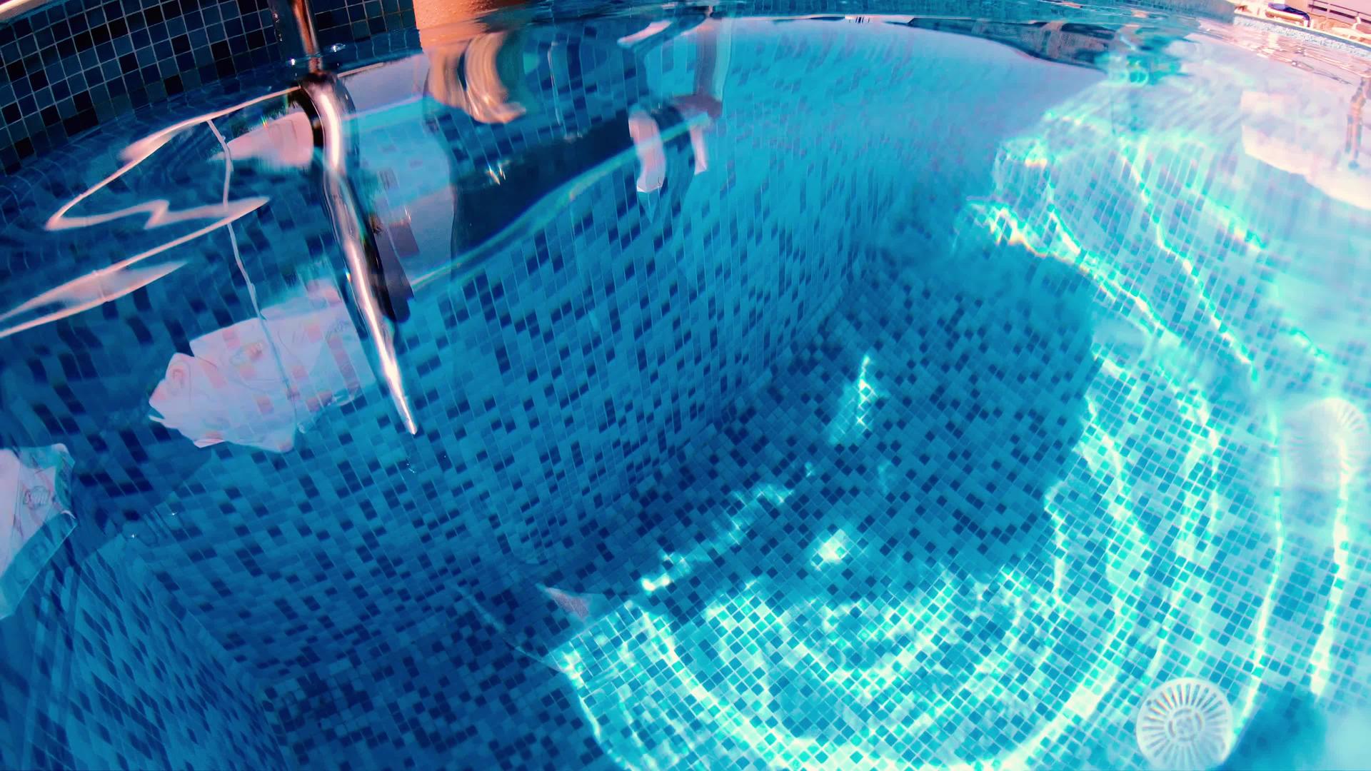 水下看着一个女人的腿在游泳池的金属梯子上慢慢地爬上去视频的预览图