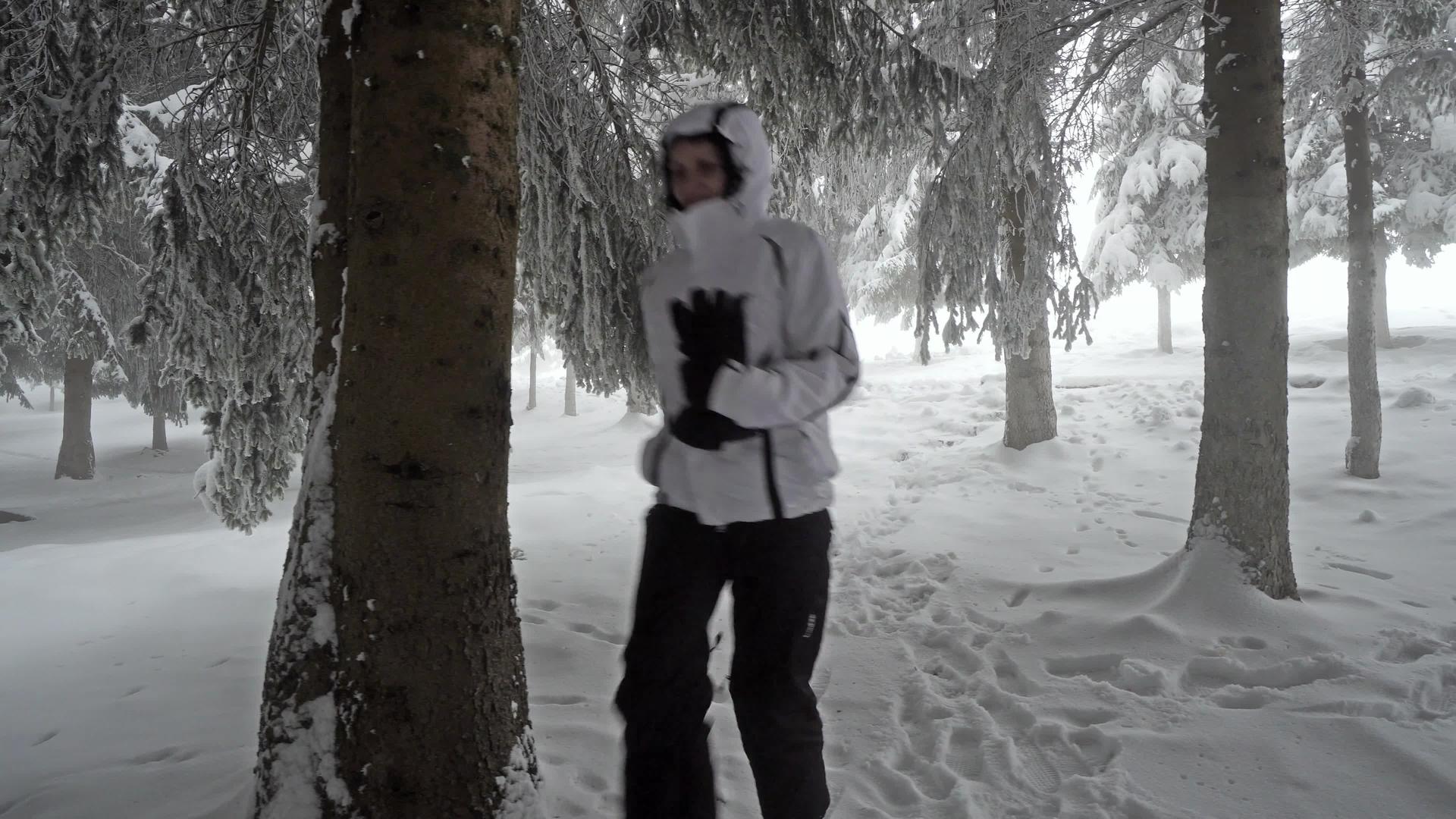 失落的女人在冬天的雪中在森林里奔跑视频的预览图