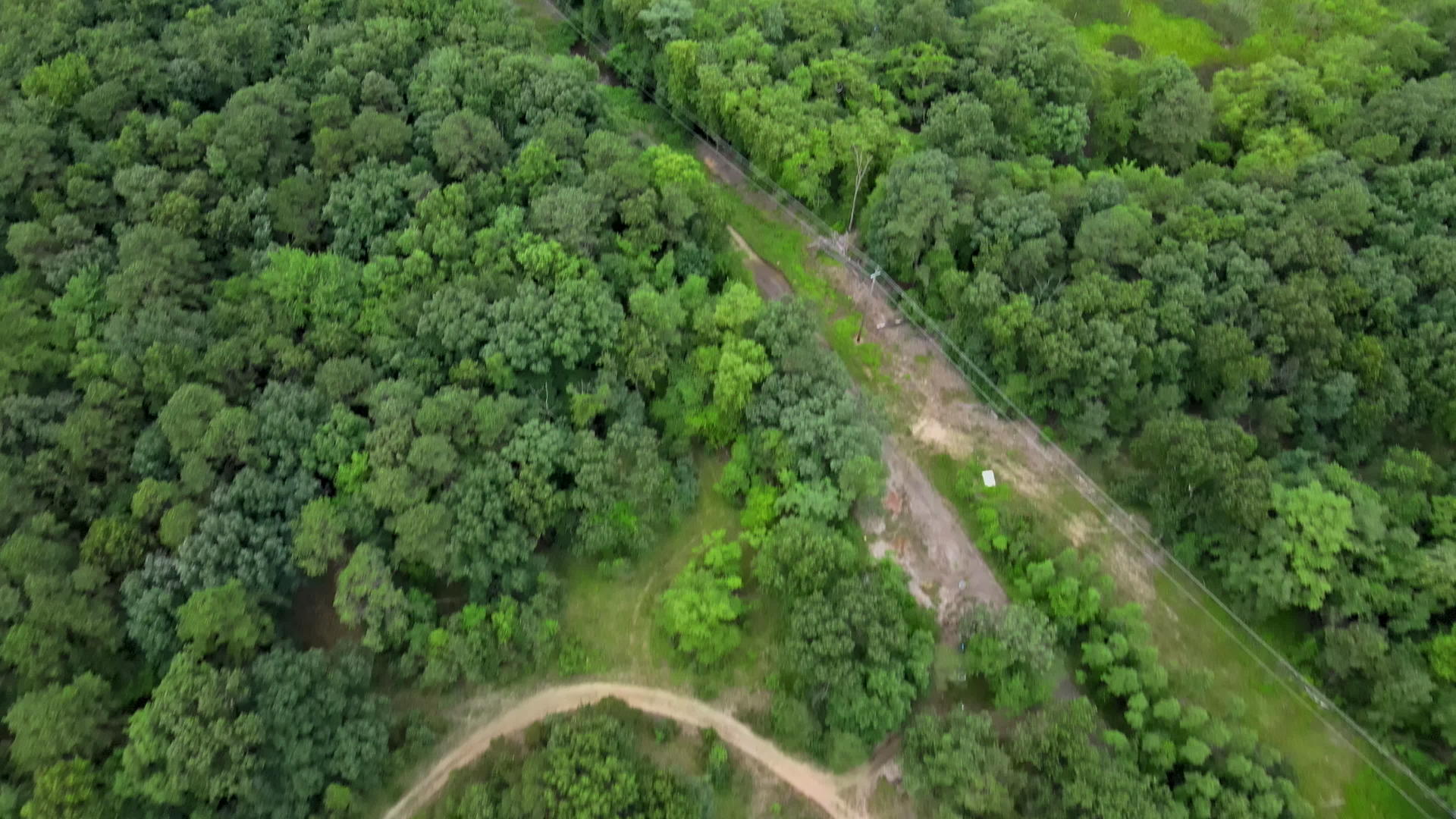 在美国美丽的夏天穿过省道绿色森林的乡村道路鸟瞰图视频的预览图