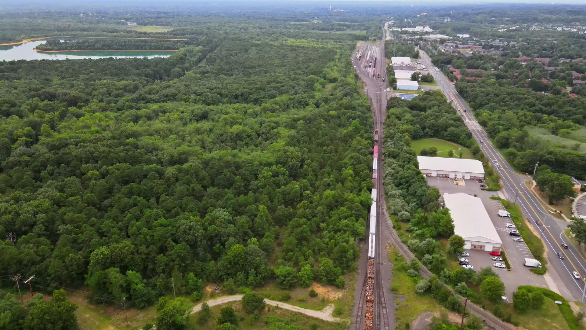 在阳光明媚的夏天无人驾驶飞机在火车铁路轨道点丰富多彩视频的预览图