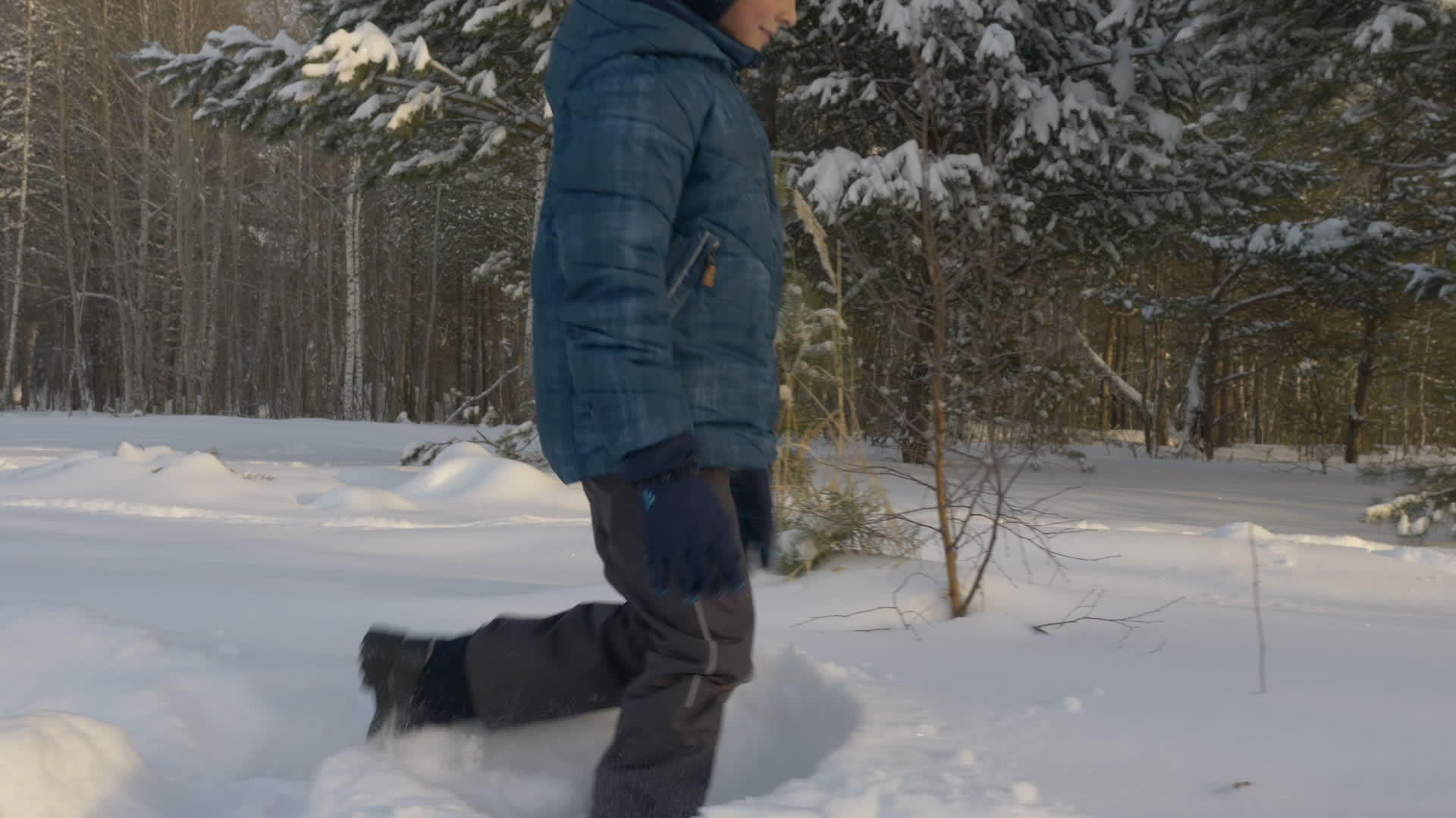 白人男孩在雪地上漫步在冬天的公园里露天视频的预览图