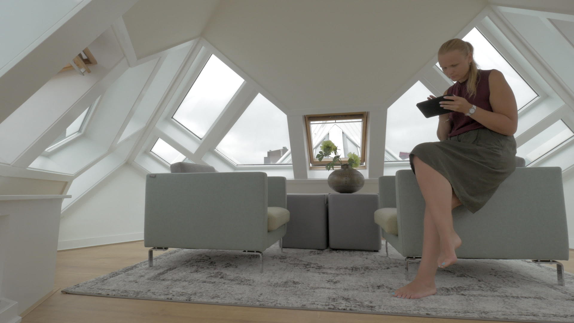 荷兰鹿特丹Cube房子里年轻的金发女郎坐在扶手椅旁边视频的预览图