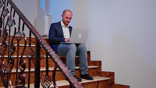 商人在楼梯上写笔记本电脑加班视频的预览图