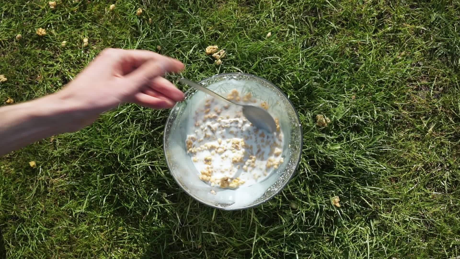 白色手工勺子在绿色草坪上搅拌木埃斯利Muesli挤压视频的预览图