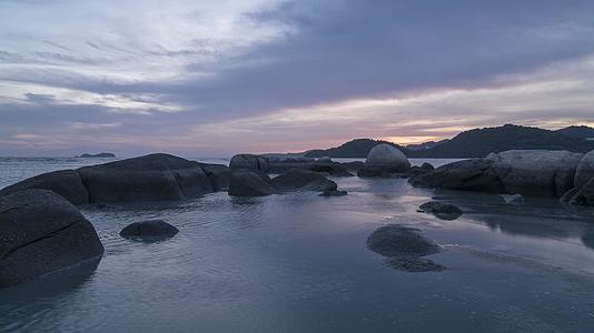 海边岩石和岩石的低潮日落时间视频的预览图