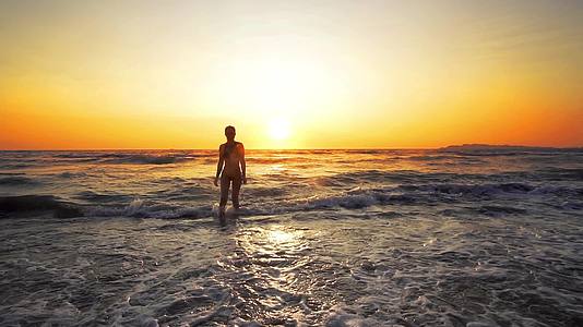 夏天在海滩上完美的身体是性感的女人日落时由波浪电影组成视频的预览图