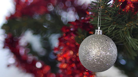 白种人的手挂在一棵闪亮的银白色圣诞树上视频的预览图