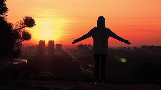 在日出时的月光下女性休眠的女性举起双手城市风景视频的预览图
