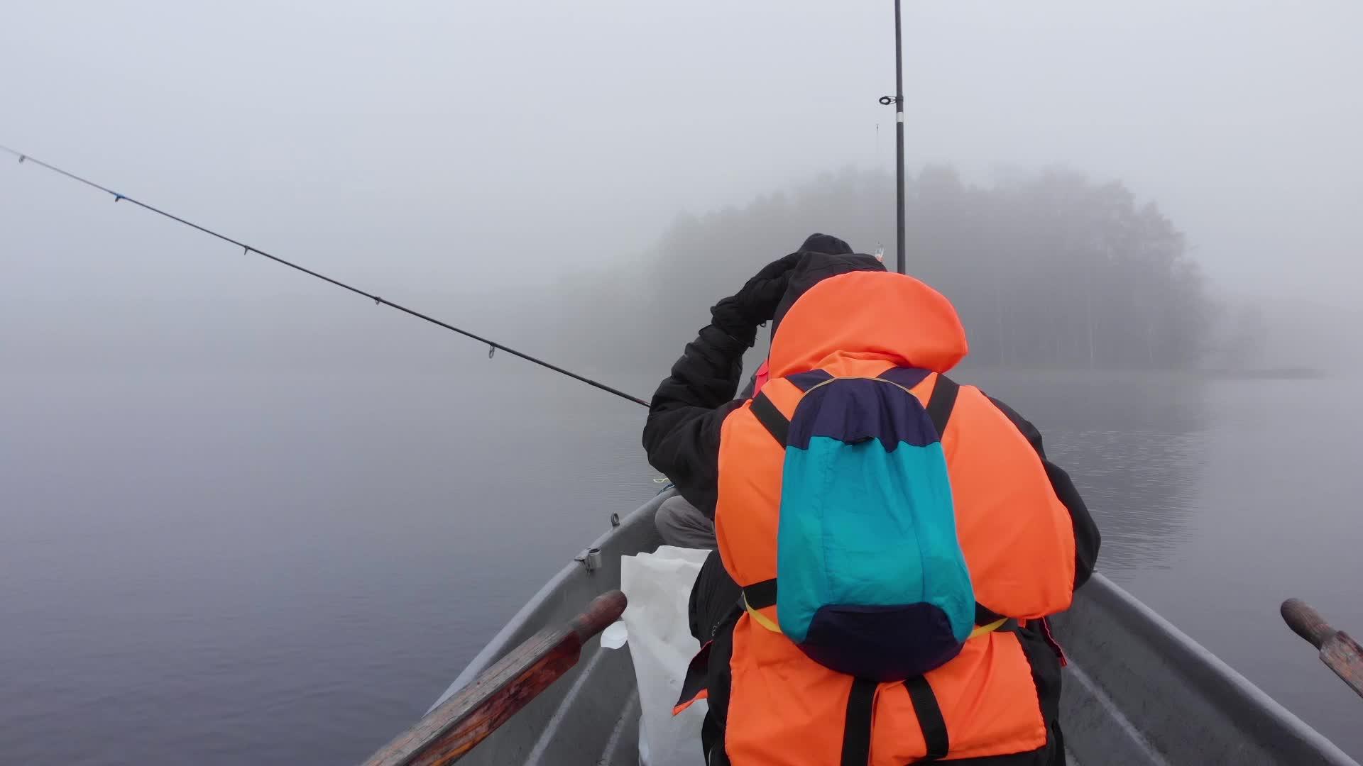 两名男子在芬兰密雾湖渔船上用棍子钓鱼视频的预览图