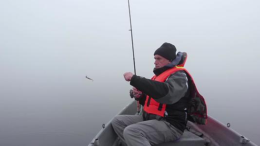 白种人在浓雾中从芬兰湖的船上捕鱼视频的预览图