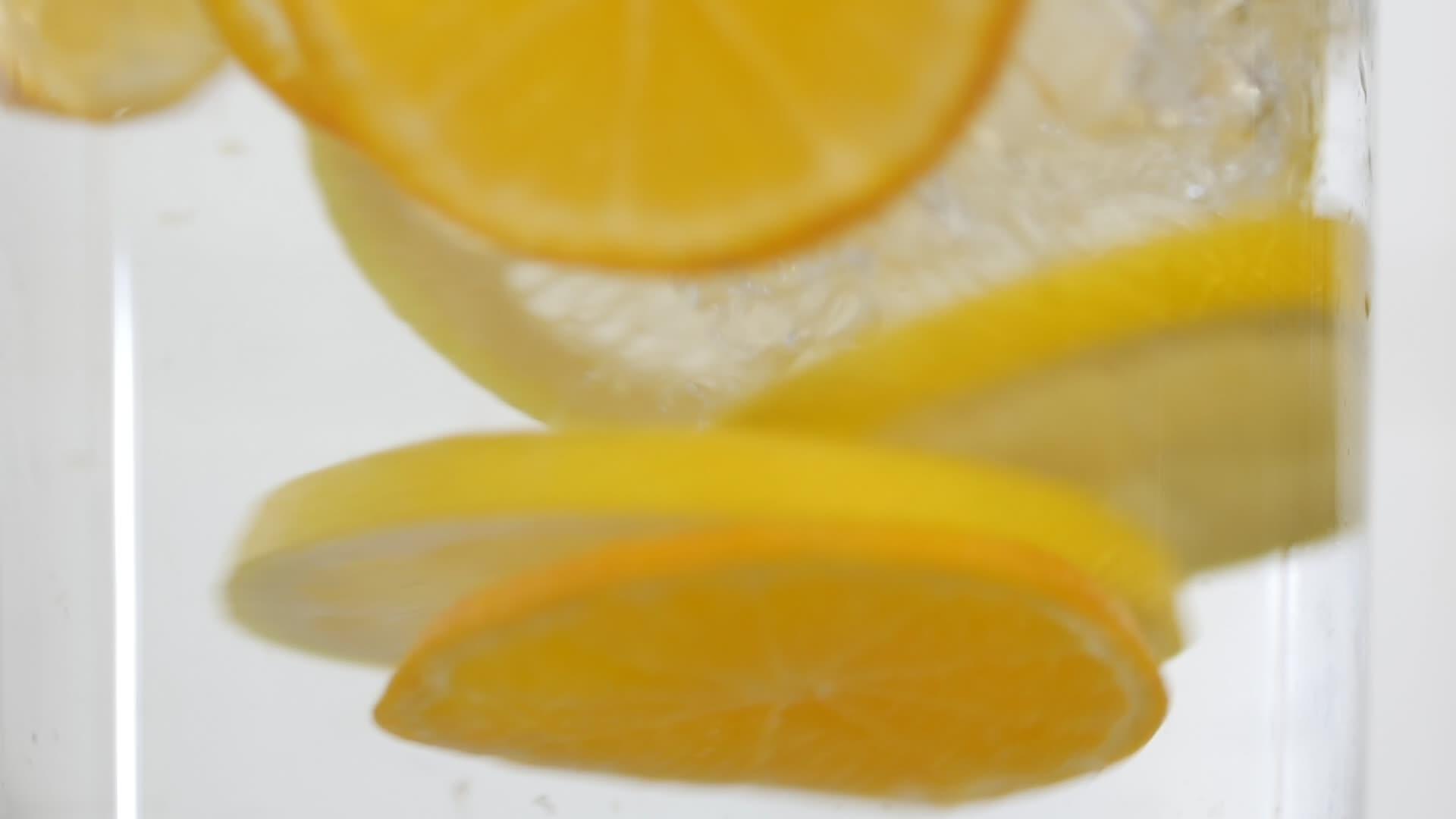 橙色水果和水滴的宏观拍摄关闭了玻璃中的新鲜饮料视频的预览图
