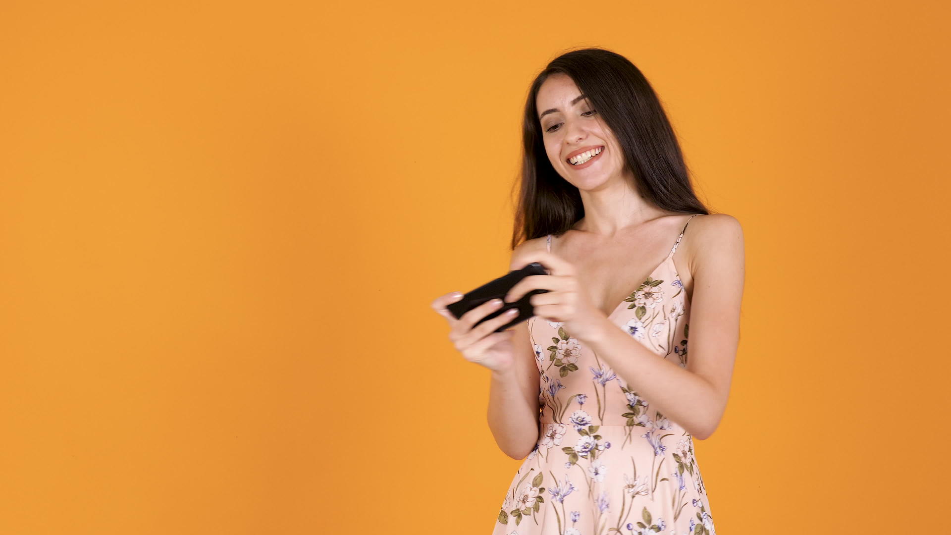 一个用智能手机玩夏装的女孩开心地笑着微笑着视频的预览图