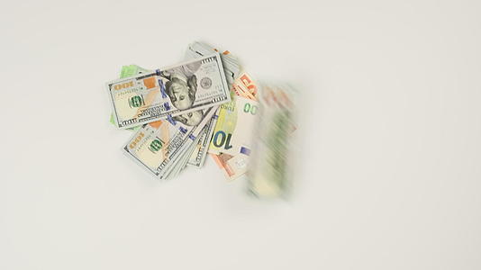 各种纸面美元和欧元钞票堆放在白色背景上视频的预览图