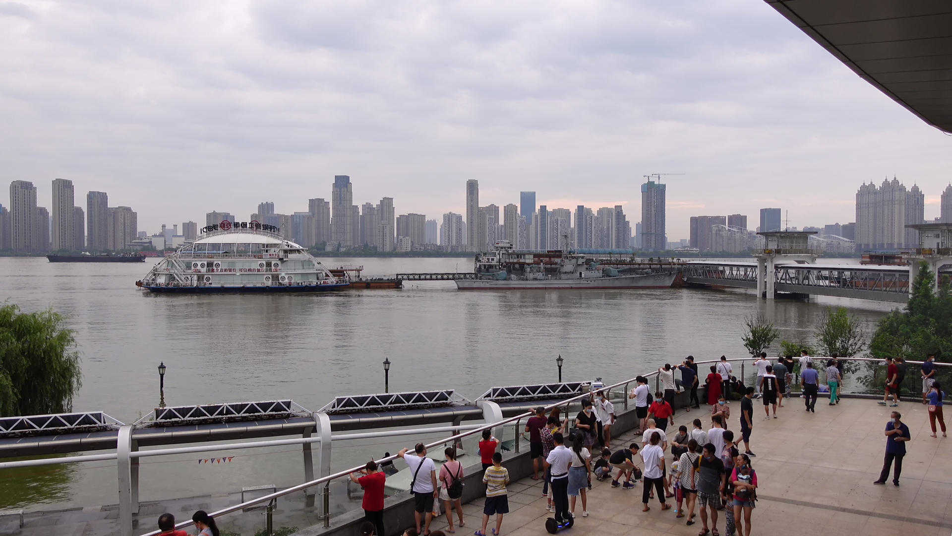 长江中下游防汛期间市民游客聚集查看水位的人群背影素材视频的预览图