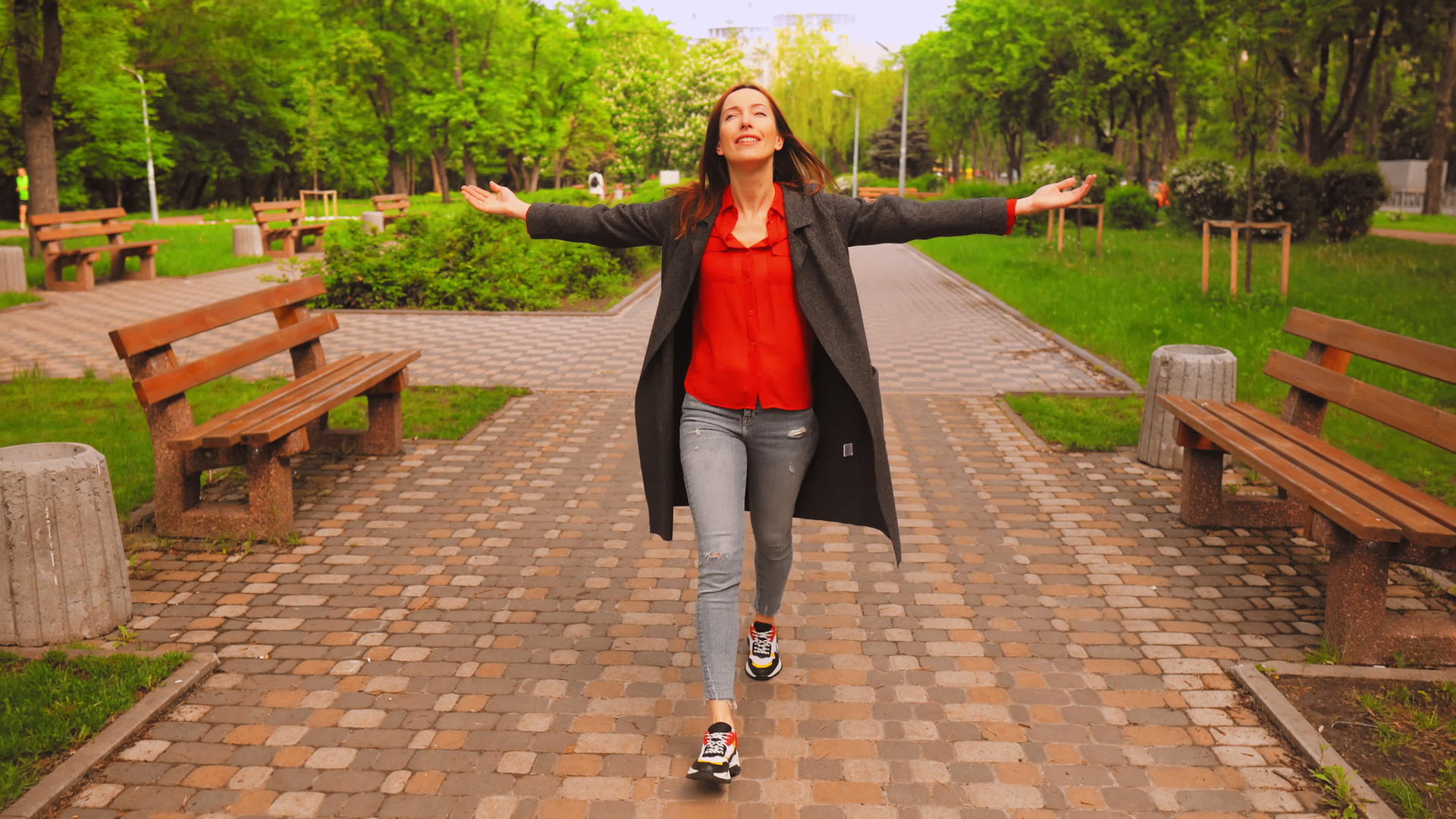 穿着灰色外套和彩色运动鞋的妇女在城市里行走视频的预览图