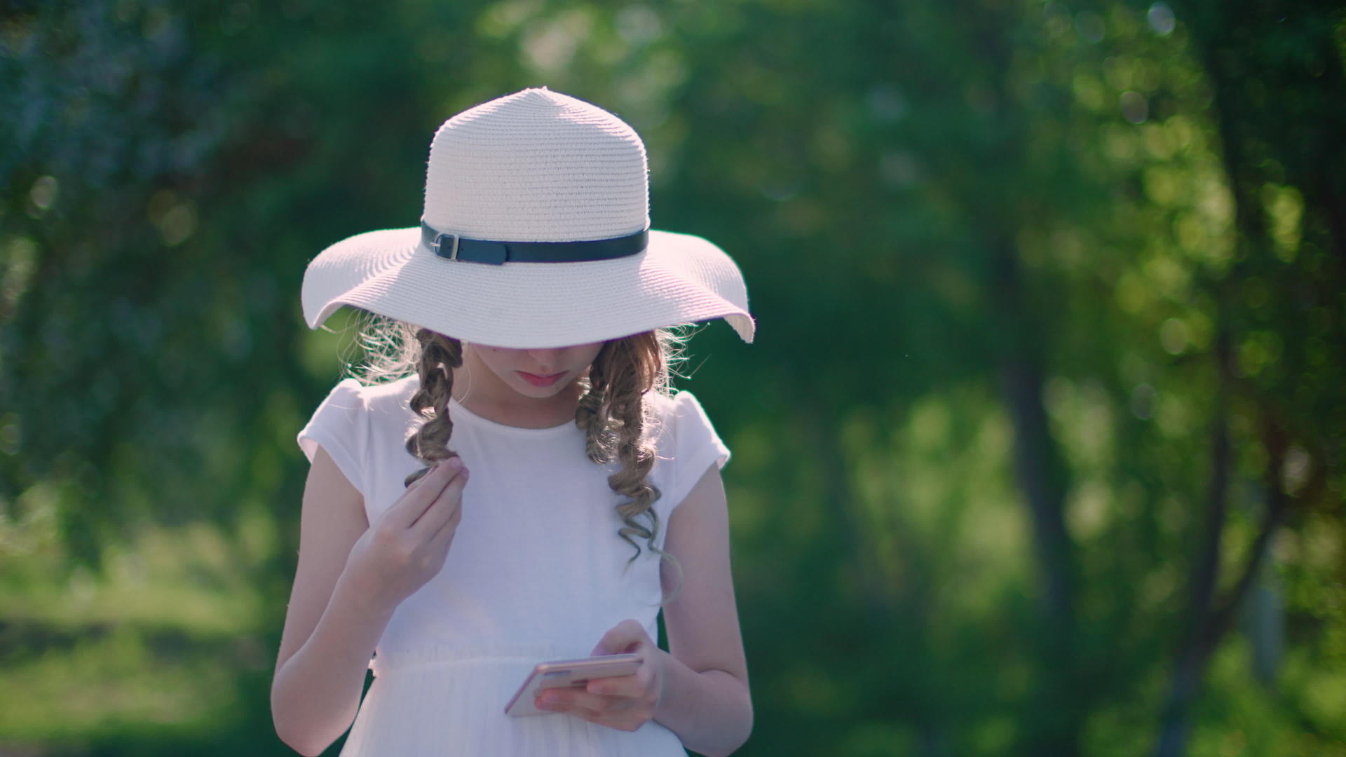 美丽的女孩在公园里使用智能手机视频的预览图