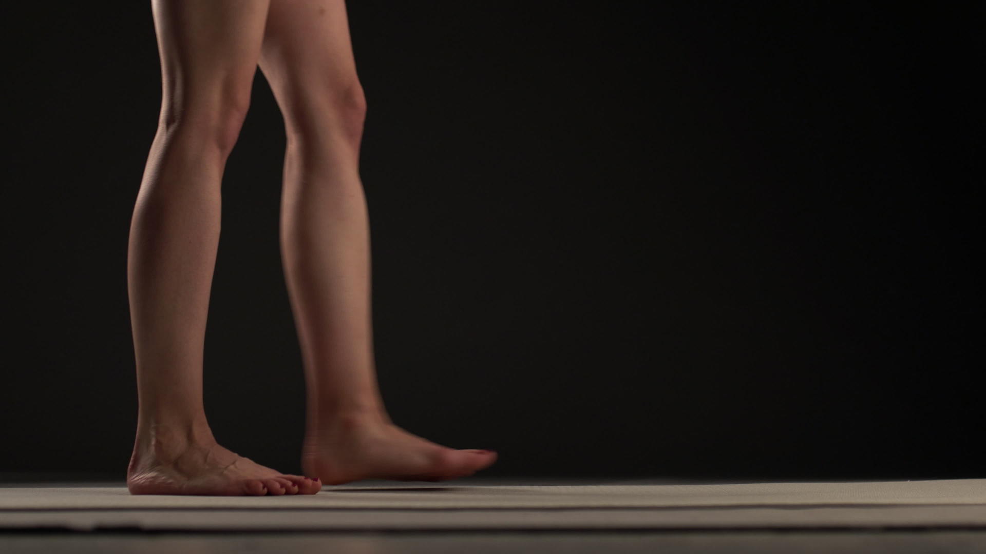 女人的腿在黑色背景下向后走向后走视频的预览图