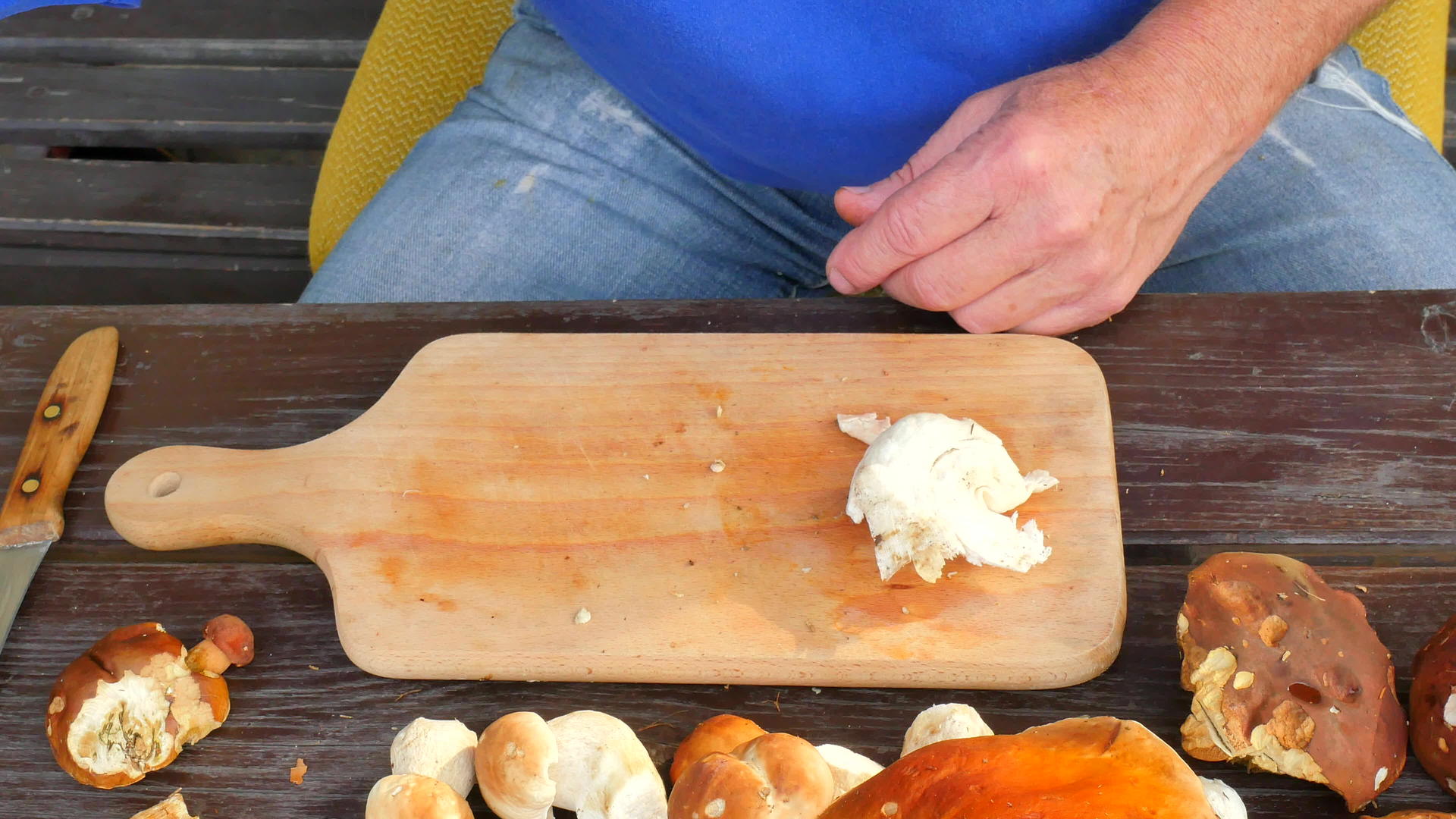 用老手上的菜刀清洗野生蘑菇小心地从茎上取蘑菇视频的预览图