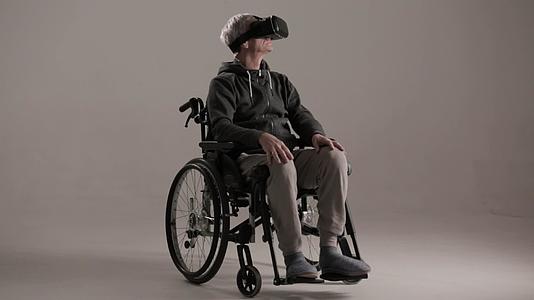 坐在轮椅上的成年人戴着虚拟现实眼镜视频的预览图