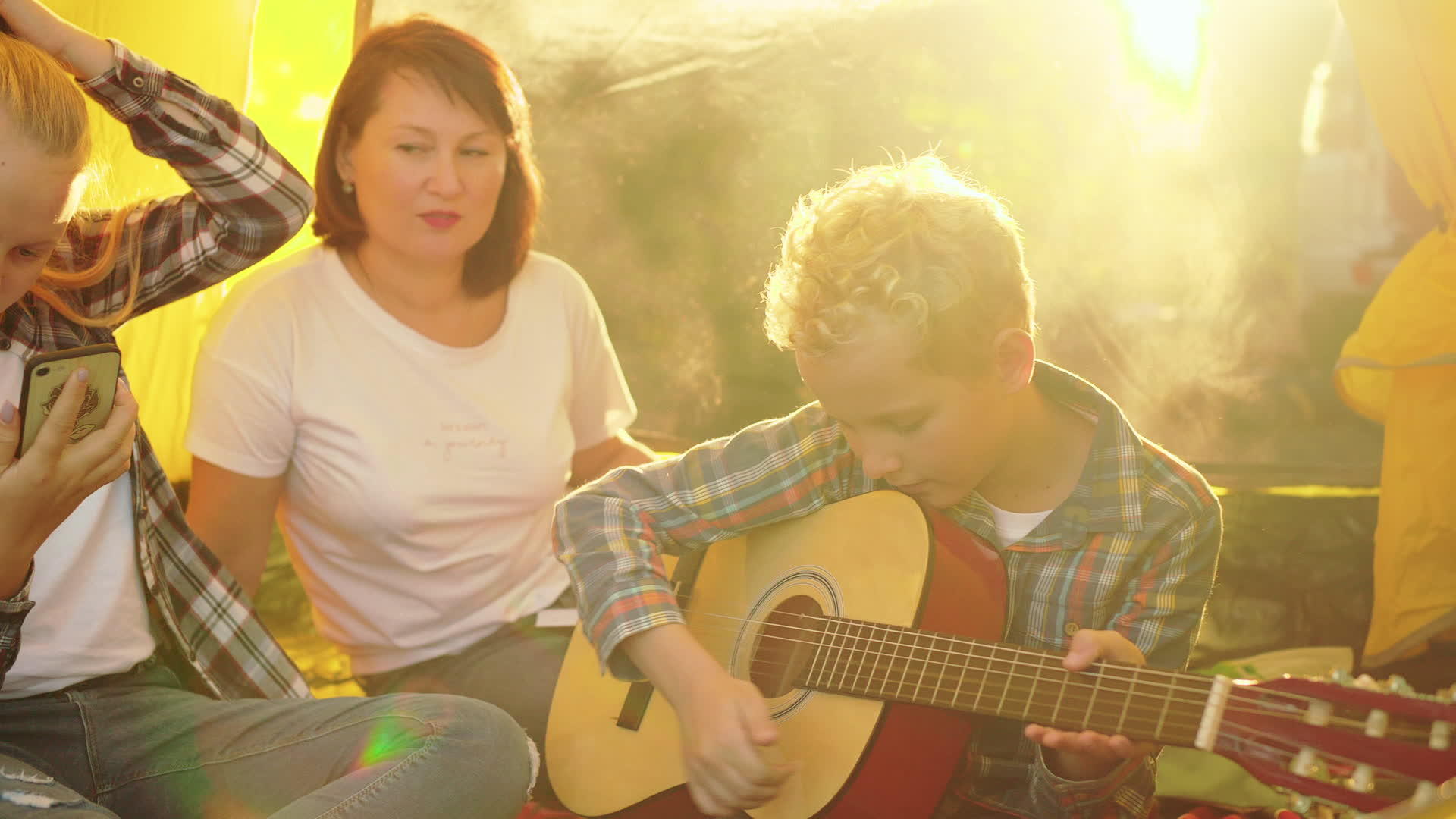 母亲、儿子和女儿在帐篷里享受吉他视频的预览图