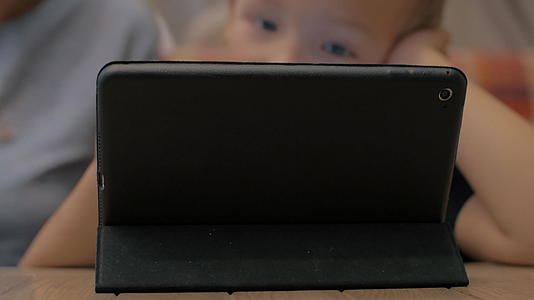 婴儿和母亲使用数字平板电脑作为娱乐产品视频的预览图