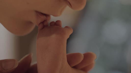 母亲亲吻新生婴儿的脚趾视频的预览图