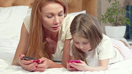 母亲用智能电话教女儿使用智能电话视频的预览图