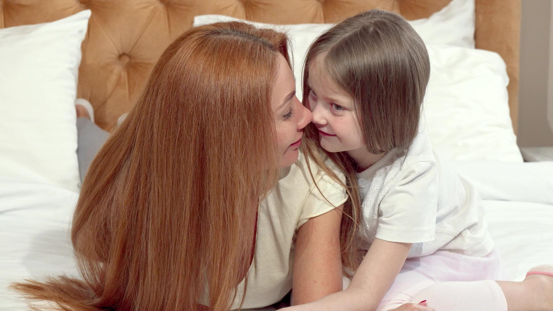 快乐的母亲和女儿在家里摩擦鼻子休息视频的预览图
