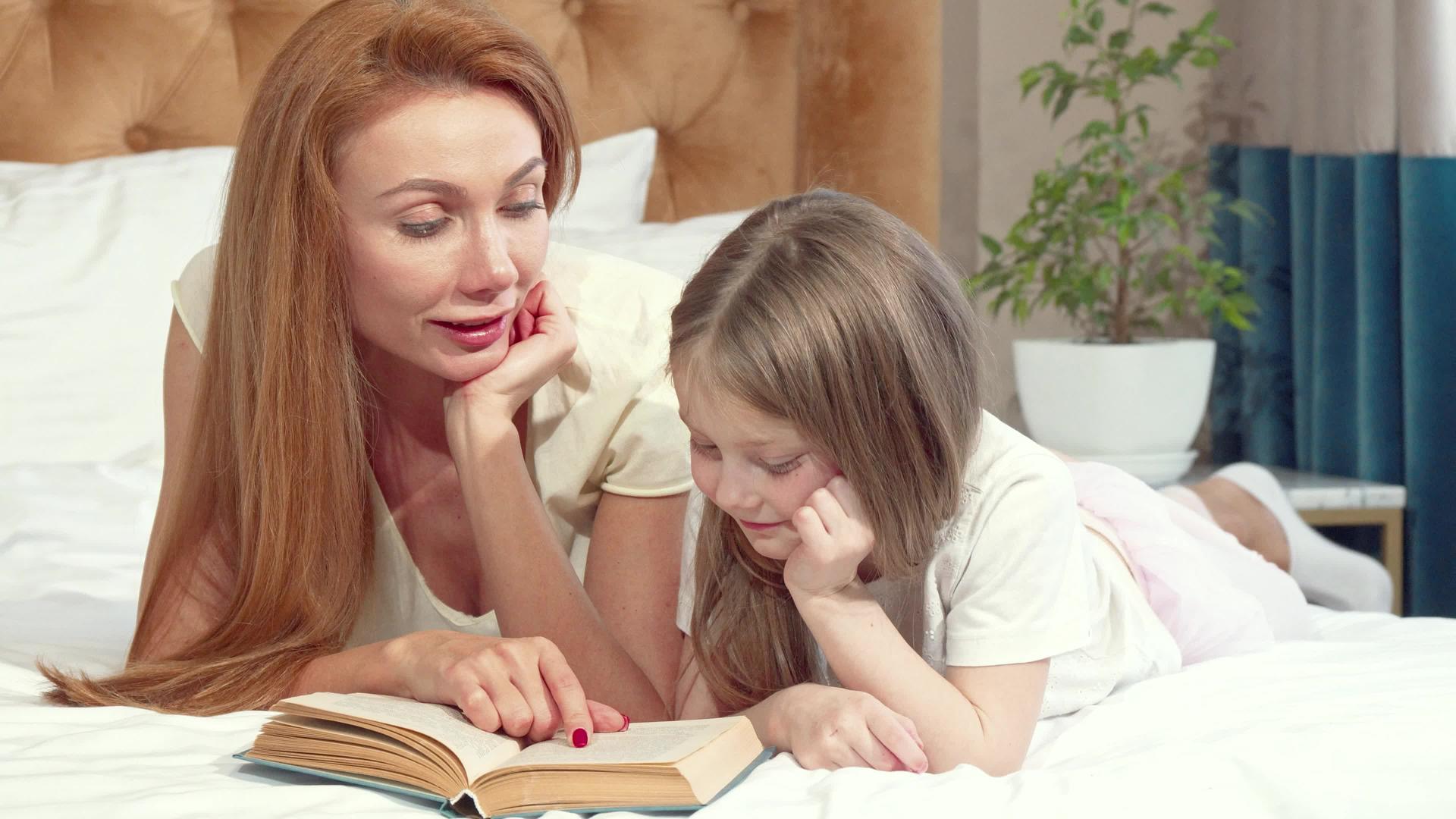可爱的小女孩和妈妈一起在家学习如何阅读视频的预览图