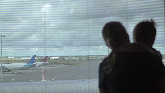孩子和母亲透过窗户看飞机透过窗户看飞机视频的预览图