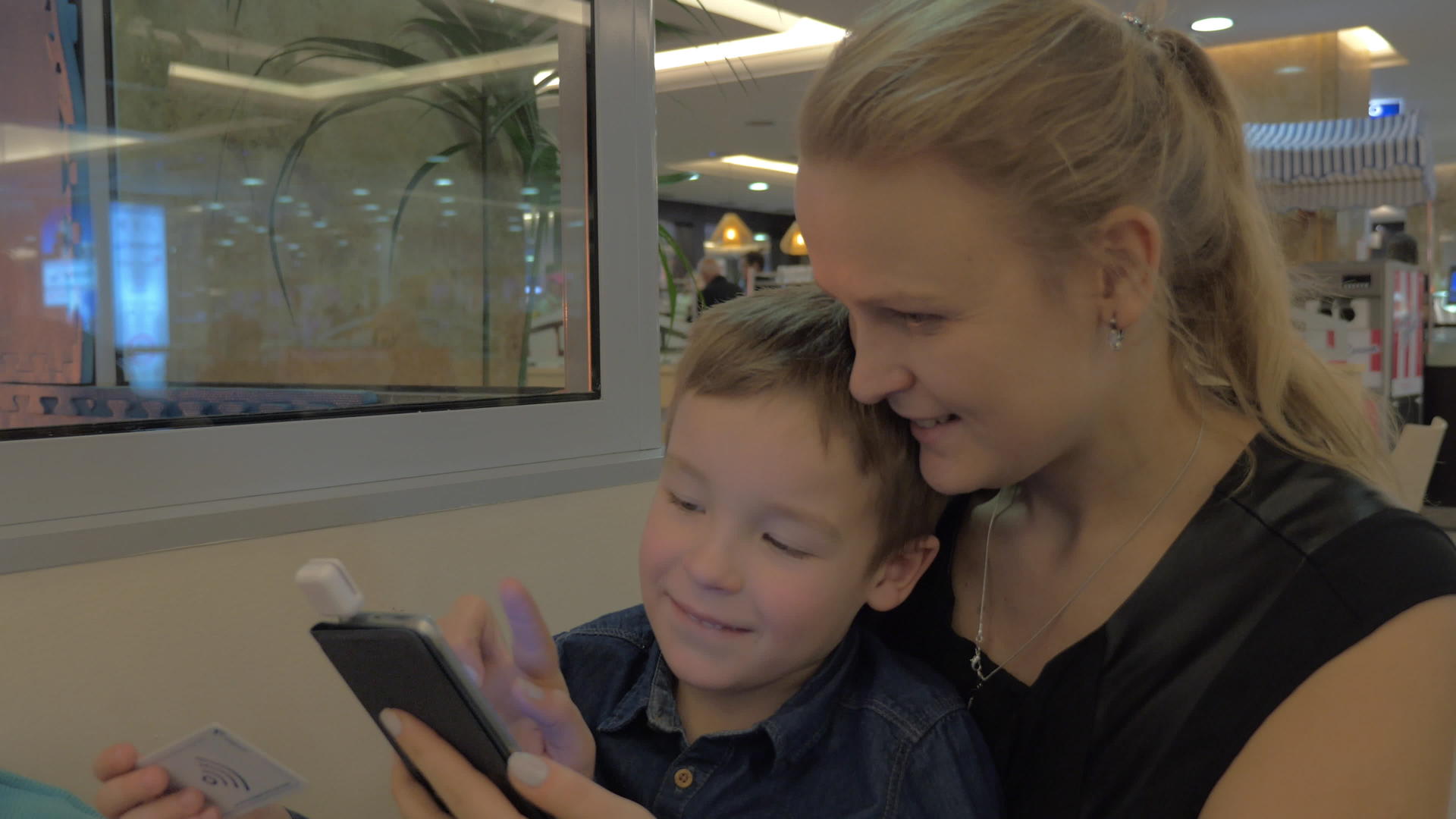 母亲和儿子用手机卡阅读器支付费用视频的预览图