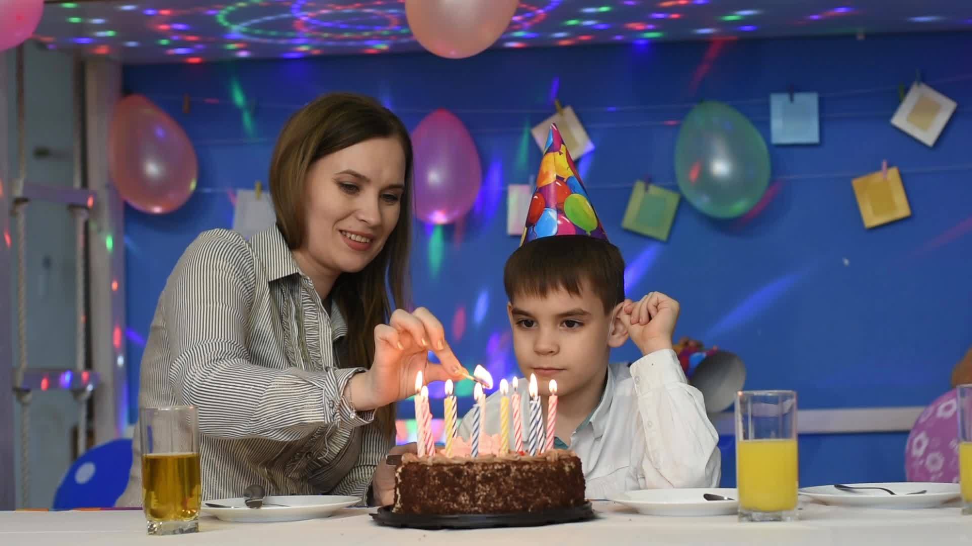 妈妈和妈妈在生日蛋糕上点蜡烛视频的预览图