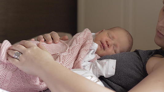 新生婴儿在母亲的胸前睡得很好视频的预览图