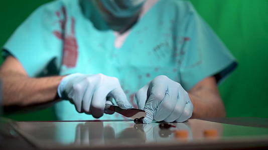 在野外医学实验室戴着口罩的邪恶外科医生用刀切刀视频的预览图