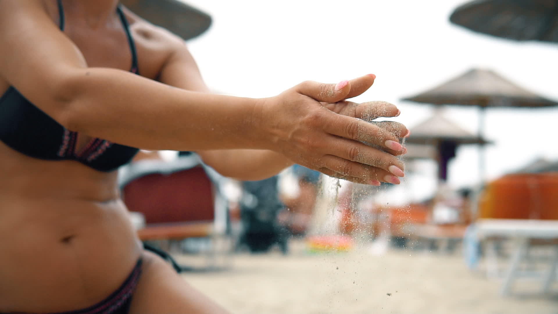 穿着比基尼的漂亮女人用慢动作从海滩清洁手视频的预览图