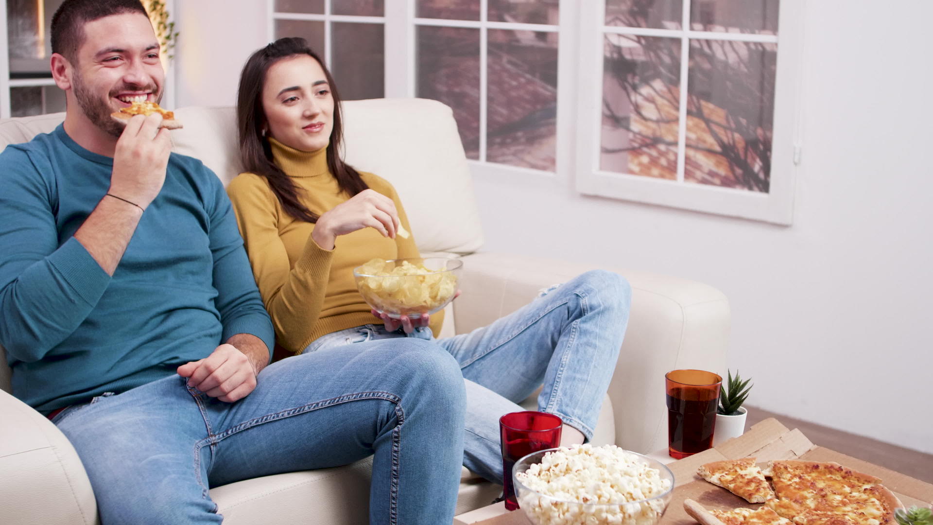 坐在沙发上吃披萨caucasian年轻夫妇视频的预览图
