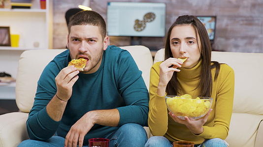 看电视和吃垃圾食品吓坏了一对夫妇视频的预览图