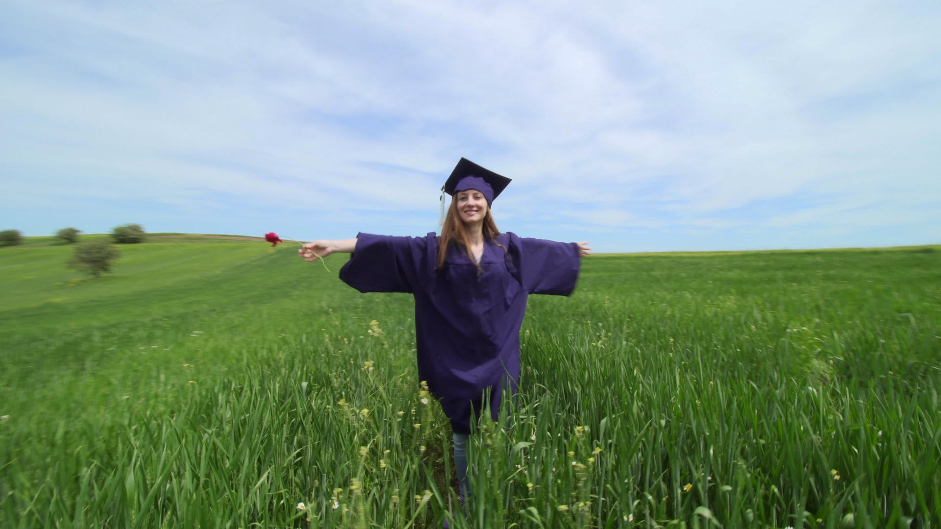 毕业女孩独自在绿色的田野里旋转有红色的郁金香虚拟毕业社交和社交视频的预览图