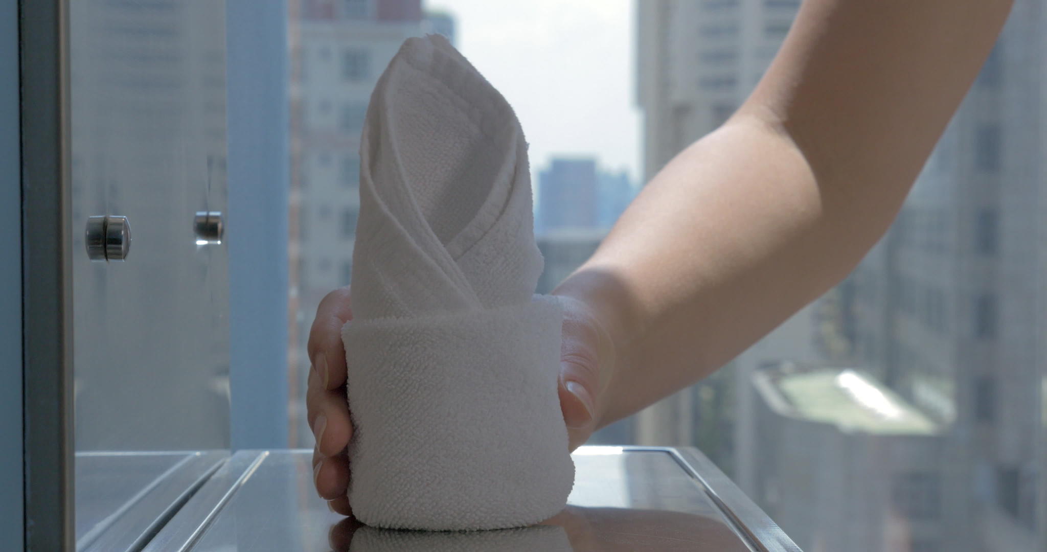 把酒店毛巾放在有城市背景的浴室里视频的预览图