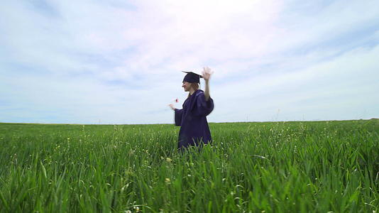 毕业女孩独自在绿色的田野里旋转有红色的郁金香虚拟毕业社交和社交视频的预览图