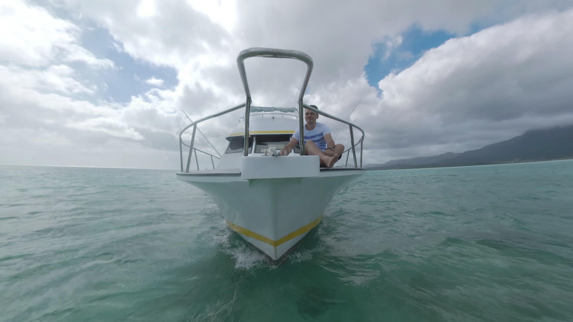 游艇和男子在前甲板上航行前往毛里提乌斯岛视频的预览图