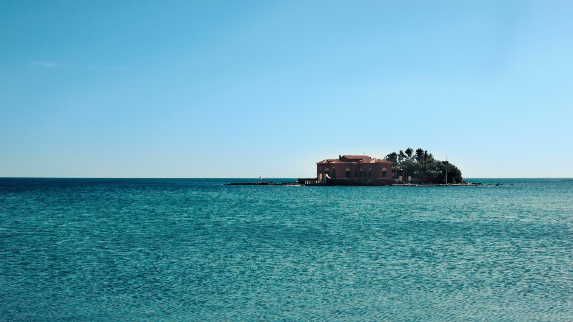 岛上环绕着一座房子周围是宁静而温柔的绿色石湾海和海视频的预览图