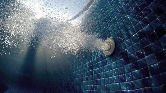 蓝色游泳池里的泡泡池里清澈的蓝色水里的气泡喷在水下视频的预览图